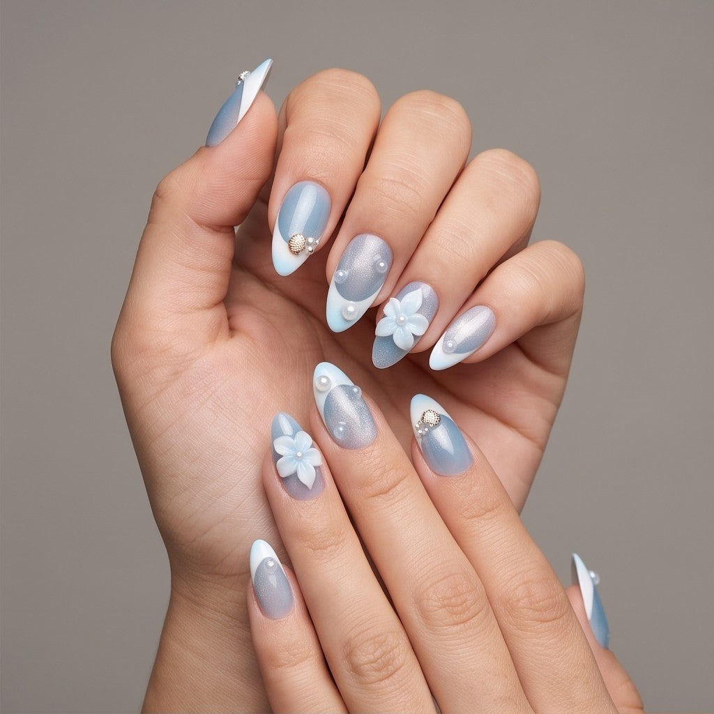 Ocean Mist – shimmer blue French tip almond press-on nails with a 3D flower and seashell charm worn on hand