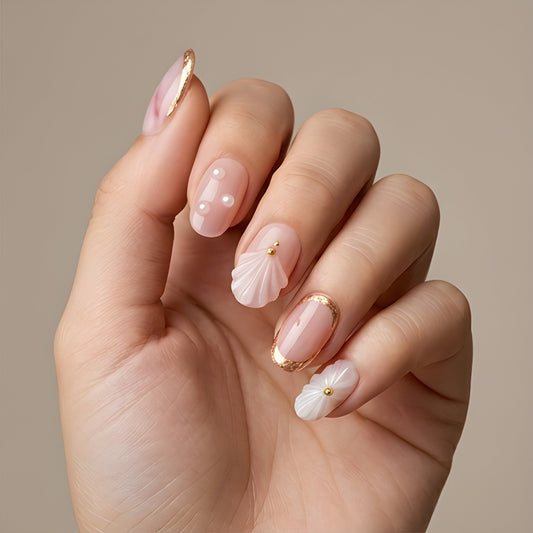 Blush Seashell – blush pink short oval press-on nails with 3D seashells, pearls and gold foil worn on hand