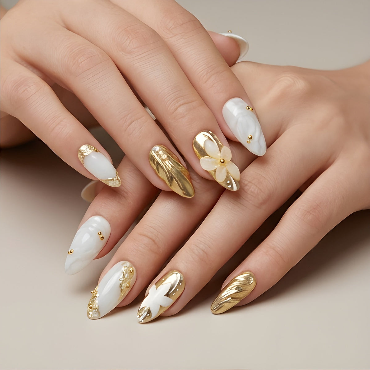 Gilded Pearl – marble white and gold chrome almond press-on nails with 3D flowers worn on hand