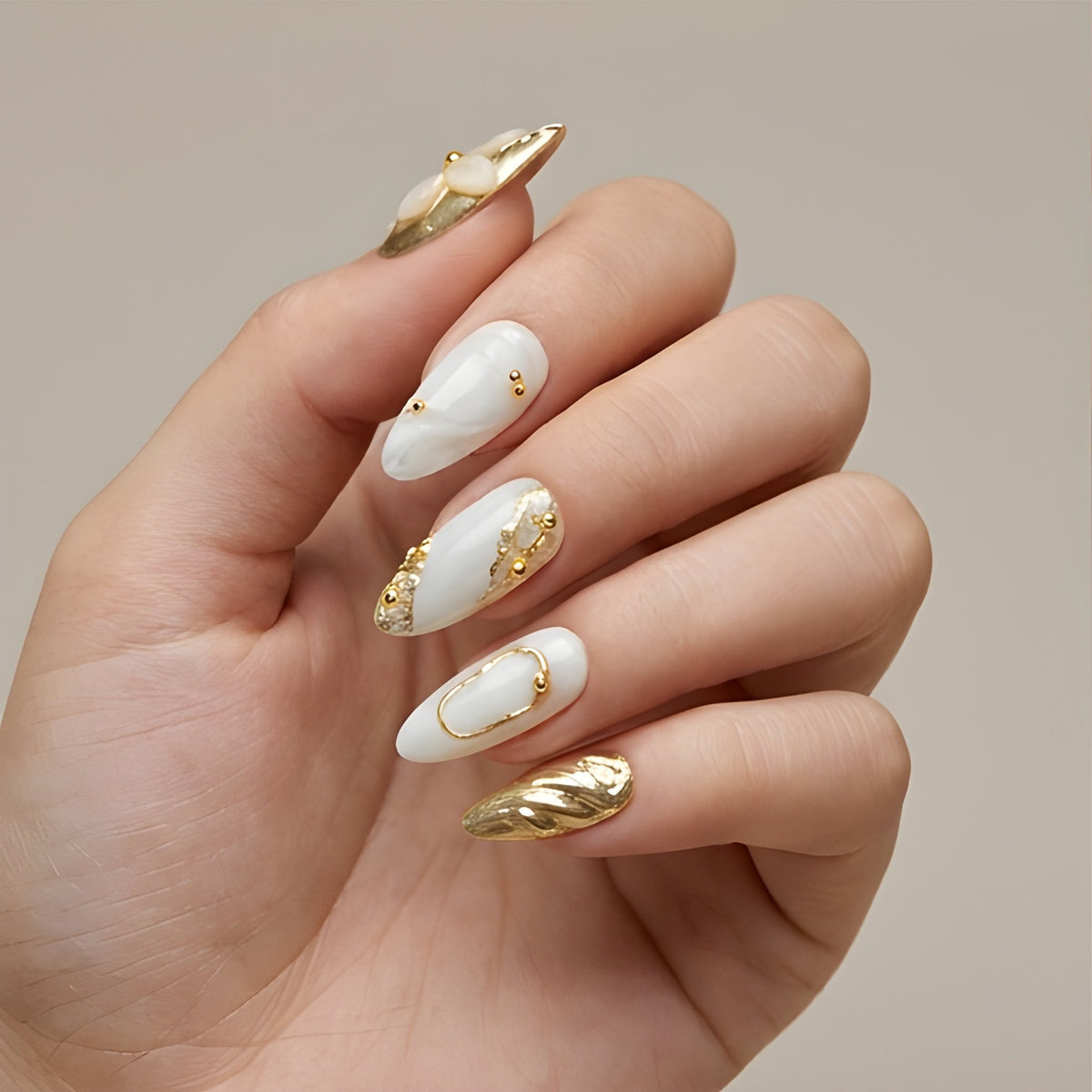 Gilded Pearl – marble white and gold chrome almond press-on nails with 3D flowers worn on hand