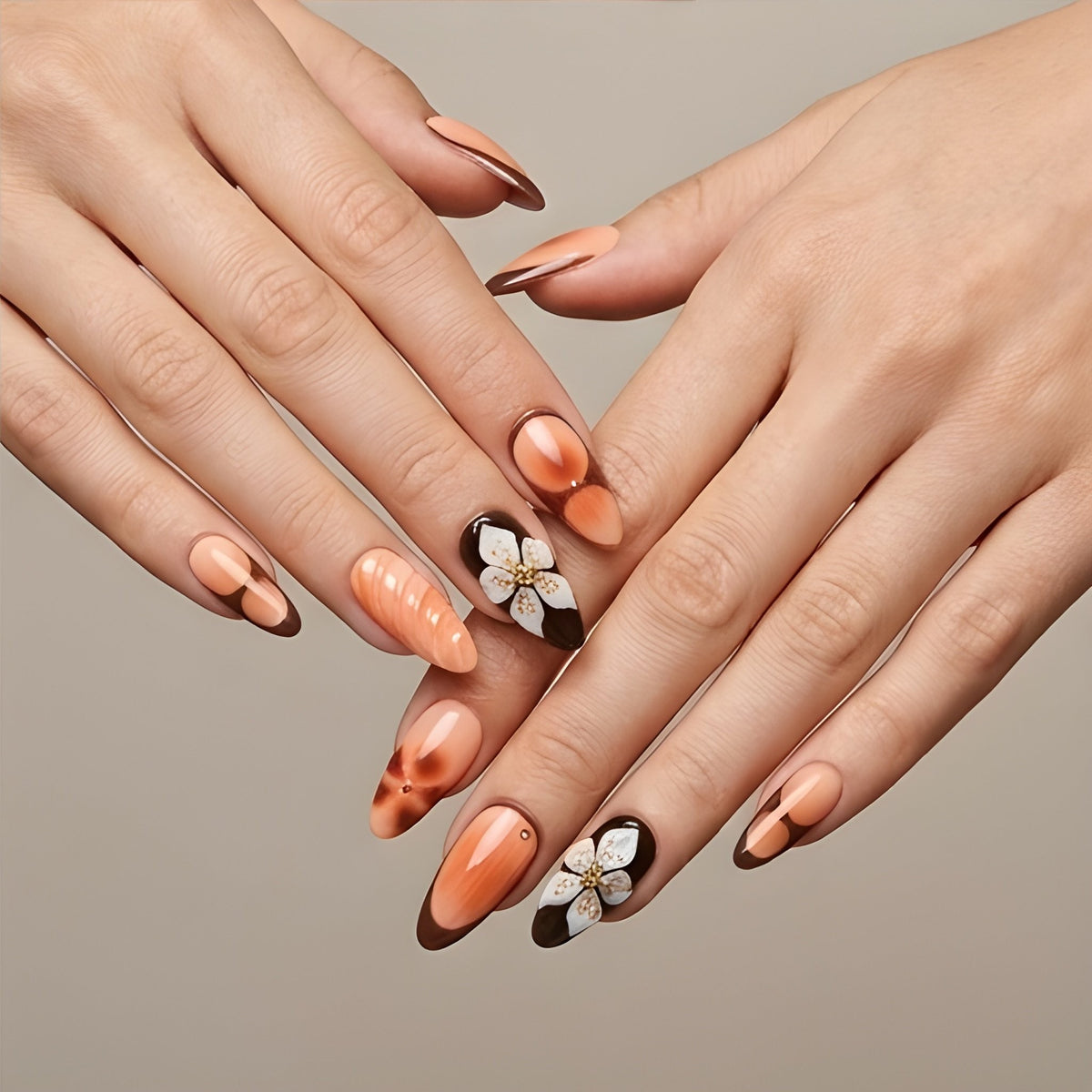 Peach Cocoa – peach and chocolate French tip almond press-on nails with 3D flowers worn on hand